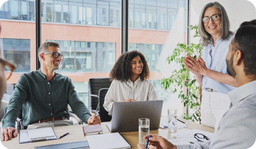 Group of men and women sit in an office setting discussing their company's culture.